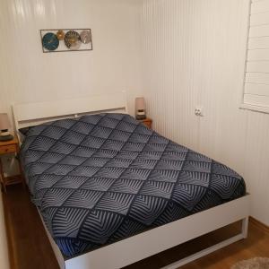 una camera da letto con un letto con un piumone bianco e nero di Het Huisje Klein maar Fijn a Bár