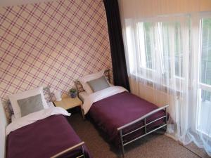 a small room with two beds and a window at Leśna Villa in Wiśniówka Mała