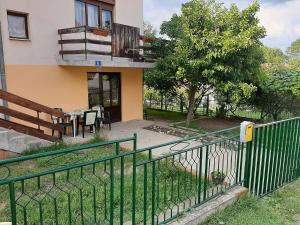 een huis met een groen hek ervoor bij Apartman Talija in Arandjelovac