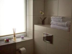 a bathroom with towels and a window and a toilet paper roll at Leśna Villa in Wiśniówka Mała