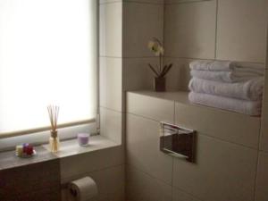 a bathroom with towels and a window and a toilet paper roll at Leśna Villa in Wiśniówka Mała +9 photos