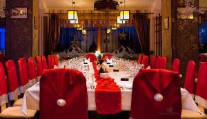 a long table in a room with red chairs at Hotel Rusu in Petroşani