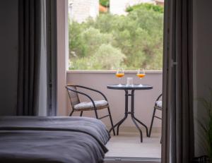2 bicchieri di vino seduti su un tavolo sul balcone di Korkyra Fit suites -free gym a Korčula