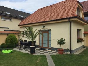 a house with a patio with a table and a house at RRR Apartmány in Bojnice