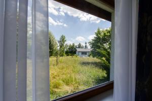 een raam met uitzicht op een veld met een huis bij HOTEL A4 Airport Kraków MOP Morawica in Aleksandrowice