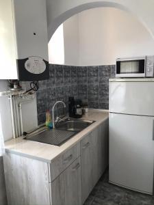 uma cozinha com um lavatório e um frigorífico branco em Apartament Andreea em Târgu-Mureş
