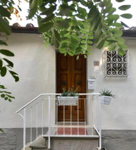 una casa con una escalera con macetas. en Rustico Rosmarino, en Castiglion Fiorentino