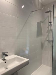 een witte badkamer met een wastafel en een douche bij 5a Bank Street in Keswick