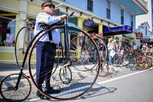 a man is holding a large bike on the street at Murray Hotel in Mackinac Island