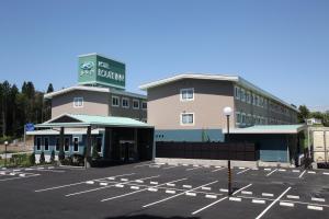 a parking lot in front of a hotel at Hotel Route Inn Kesennuma Chuo Inter in Kesennuma