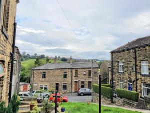 a view from the street of an old stone house at Bronte Railway Cottage at Haworth in Haworth