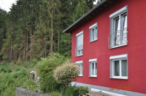 a red house with white windows on a mountain at Ferienwohnung Idarblick in Idar-Oberstein