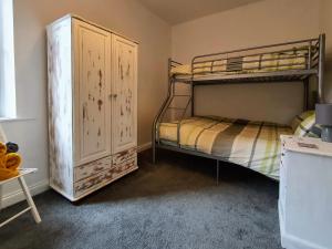 Двухъярусная кровать или двухъярусные кровати в номере Bronte Cinema Cottage At Haworth