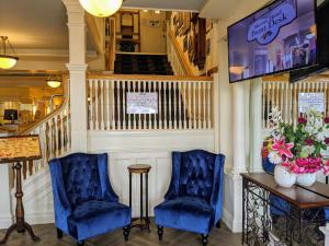 2 sillas azules y una mesa en una habitación en Murray Hotel en Mackinac Island