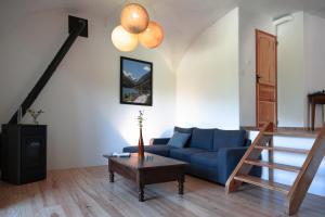 ein Wohnzimmer mit einem blauen Sofa und einem Tisch in der Unterkunft MaisonNel Gîte in Saint-Bonnet-en-Champsaur