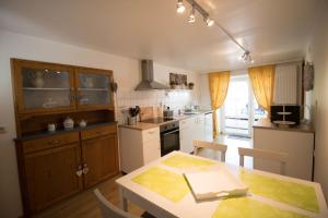 a kitchen with a table and a dining room at Carmius - Back to simple life in Burg-Reuland