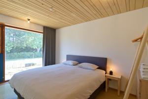 a bedroom with a large bed and a large window at Duinvis 15 in Oostduinkerke