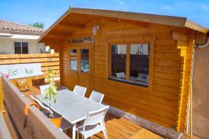 a wooden cabin with a table and chairs on a deck at Le chalet aux Etoiles Spa & Sauna in Pézenas