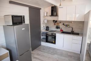 uma cozinha com armários brancos e um frigorífico em Le chalet aux Etoiles Spa & Sauna em Pézenas