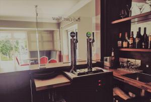 a bar with a counter with bottles of wine at Earls Court House in Killarney