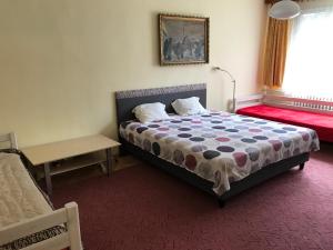 a bedroom with a bed and a table and a window at Sunny appartment by the river in Dolný Kubín