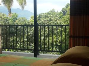 a bedroom with a balcony with a view of the forest at Hanthana view in Peradeniya