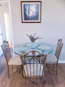 a glass table with chairs and a vase on it at Downtown Apartment convenient to all city venues 105 in Greensboro