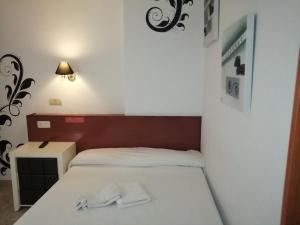 um quarto com uma cama com duas toalhas brancas em Hostal Jaime I em Huesca