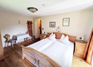 a bedroom with a large white bed and a desk at Haus Marienheim in Heiligenblut