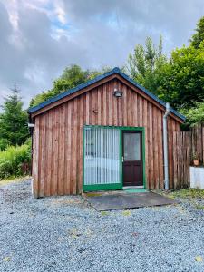 a small wooden building with a green door at Hazelmount Self-Catering Cabin in Portree