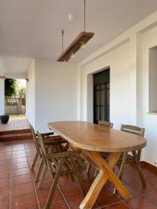 a dining room with a wooden table and chairs at Allotjament lo Ribé in Deltebre