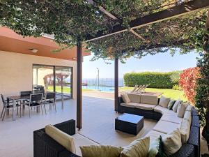 eine Außenterrasse mit Sofas, einem Tisch und Stühlen in der Unterkunft Villa Vitoria - by LovelyStay in Funchal