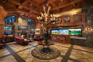 a living room with a large fireplace and a chandelier at Wyoming Inn of Jackson Hole in Jackson
