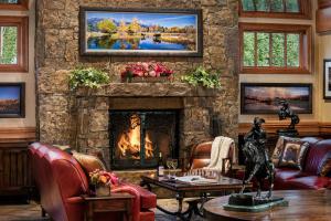 a living room with a fireplace and a stone wall at Wyoming Inn of Jackson Hole in Jackson