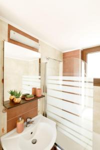 y baño con lavabo y espejo. en "Oak Wood" - Sea View Holidays Home by Sky Hill Resorts en Sfakaki