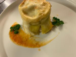 a white plate with a piece of food with broccoli at Hotel Alaska in Selva di Val Gardena