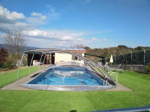 una piscina con cubierta en un campo de césped en Casa - Chalet Madera Canadiense, en Santa Cruz de Campezo