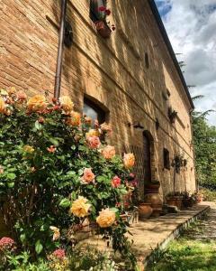 a brick building with flowers on the side of it at Countryhouse Montebello in Grottazzolina