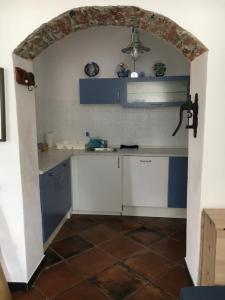 a kitchen with blue and white cabinets and an archway at Casetta del Marinaio in Camogli