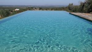 una grande piscina di acqua blu con vista di Quinta de Evoramonte a Estremoz