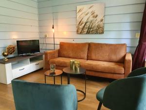 a living room with a couch and a tv at De Patrijs in Oudemirdum