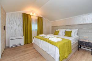 a bedroom with a large bed with yellow curtains at Luxury Apartments Queen in Petrovac na Moru