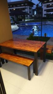 um banco de madeira sentado em frente a uma piscina em Cupe Beach Living Flat em Porto de Galinhas