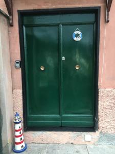 een groene deur met een bord erop bij Casetta del Marinaio in Camogli