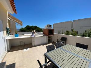 a patio with a table and chairs on a roof at CASA FANFAMARE in Sesimbra