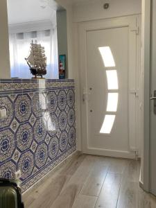 a room with a white door and a tile wall at CASA FANFAMARE in Sesimbra