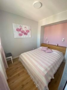 um quarto com uma cama com riscas cor-de-rosa e brancas em Apartament na Wspólnej ( centrum, garaż ) em Kielce