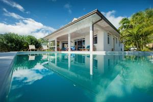 a swimming pool in front of a house at Villa Tepoe Pool and Beach in Moorea