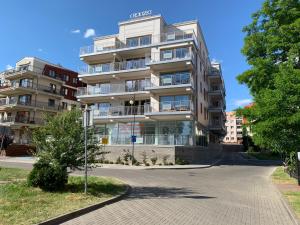un grand immeuble d'appartements avec un panneau de rue devant lui dans l'établissement Marina Blue-Apartament przy promenadzie, à Ełk