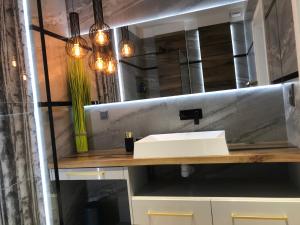 une salle de bains avec un lavabo et un miroir dans l'établissement Marina Blue-Apartament przy promenadzie, à Ełk 15 autres photos